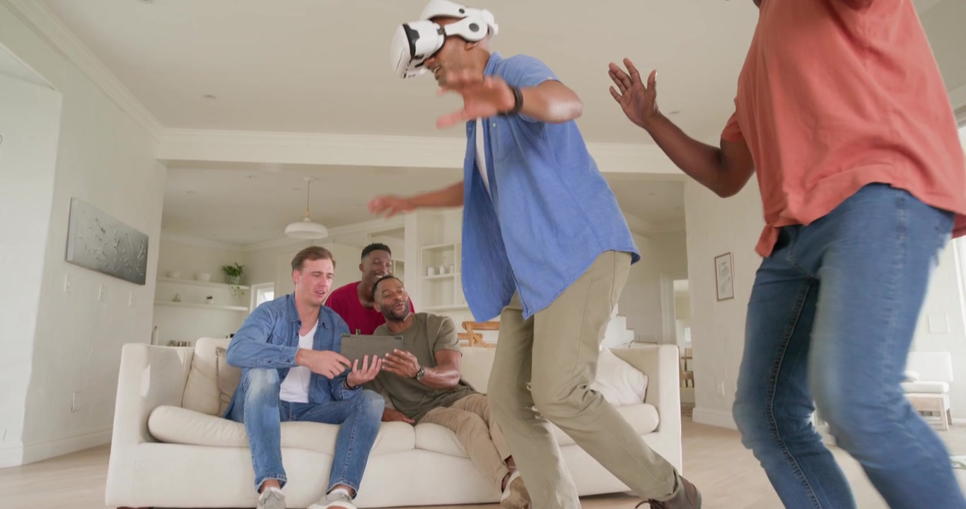 Vertical video: Diverse male friends with VR swaying while trio tapping tablet guiding play at home