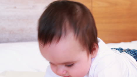 Smiling-baby-boy-on-a-bed