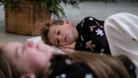 children are sleeping near the christmas tree they are waiting for christmas gifts from santa claus children are sleeping near the christmas tree they are waiting for christmas gifts from santa claus brother and sister are sleeping