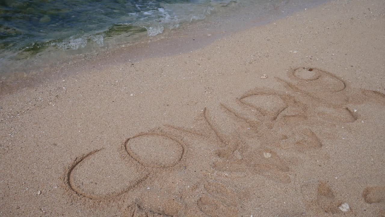 파도에 의해 지워진 해변 백사장에 covid19 글자