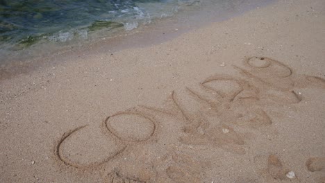 covid19 lettering on beach white sand erased by waves