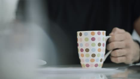 Mann-Hält-Kaffeetasse-In-Der-Hand.-Nahaufnahme-Einer-Männlichen-Hand,-Die-Sich-Darauf-Vorbereitet,-Tee-Zu-Trinken