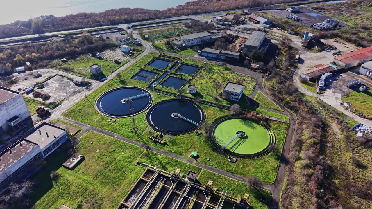 Water treatment facility with tanks and surrounding area in daytime