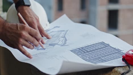 close up of the caucasian and african american male and female hands with some drafts and charts while architects talking and explaining something to each other.