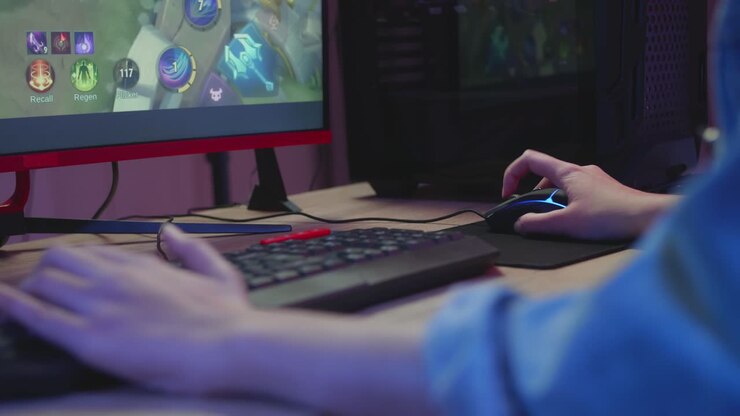 Piges hænder bruger tastaturet, mens hun spiller videospil