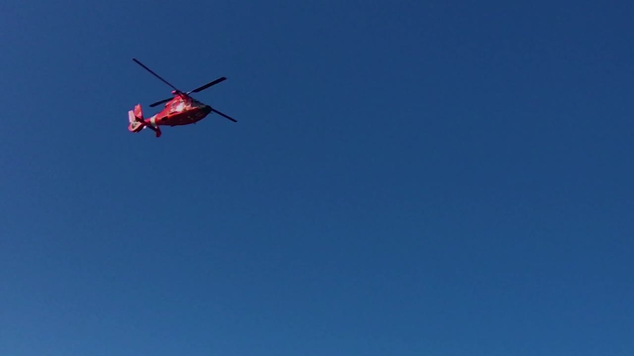 빨간색 헬리콥터 헬기가 미국 캘리포니아주 샌프란시스코를 배경으로 금문교를 배경으로 머리 위로 날아갑니다.