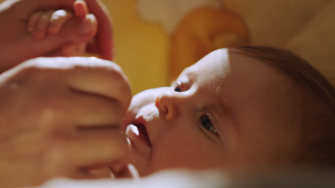 보육자 가 아기 의 발 을 들고 있는 것