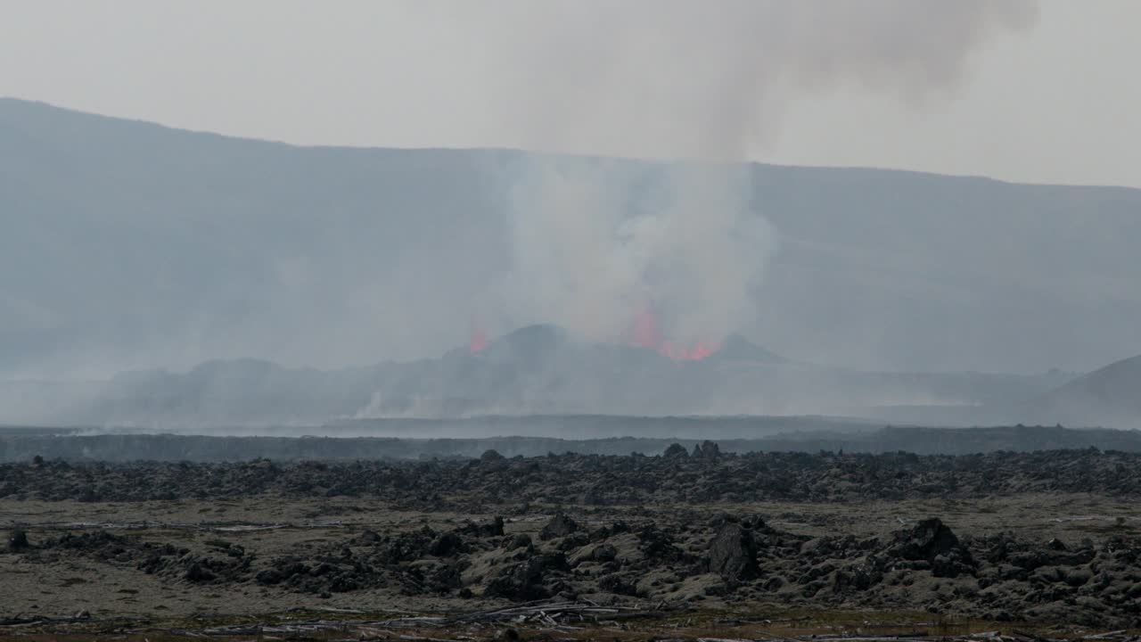 vista lejana del volcán grindavik en erupción en el cráter sundhnúkur, islandia, con humo y lava visibles