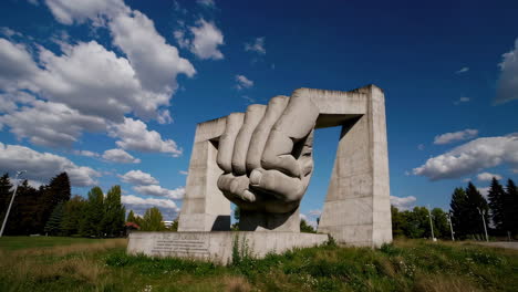 massive concrete fist sculpture against a blue sky
