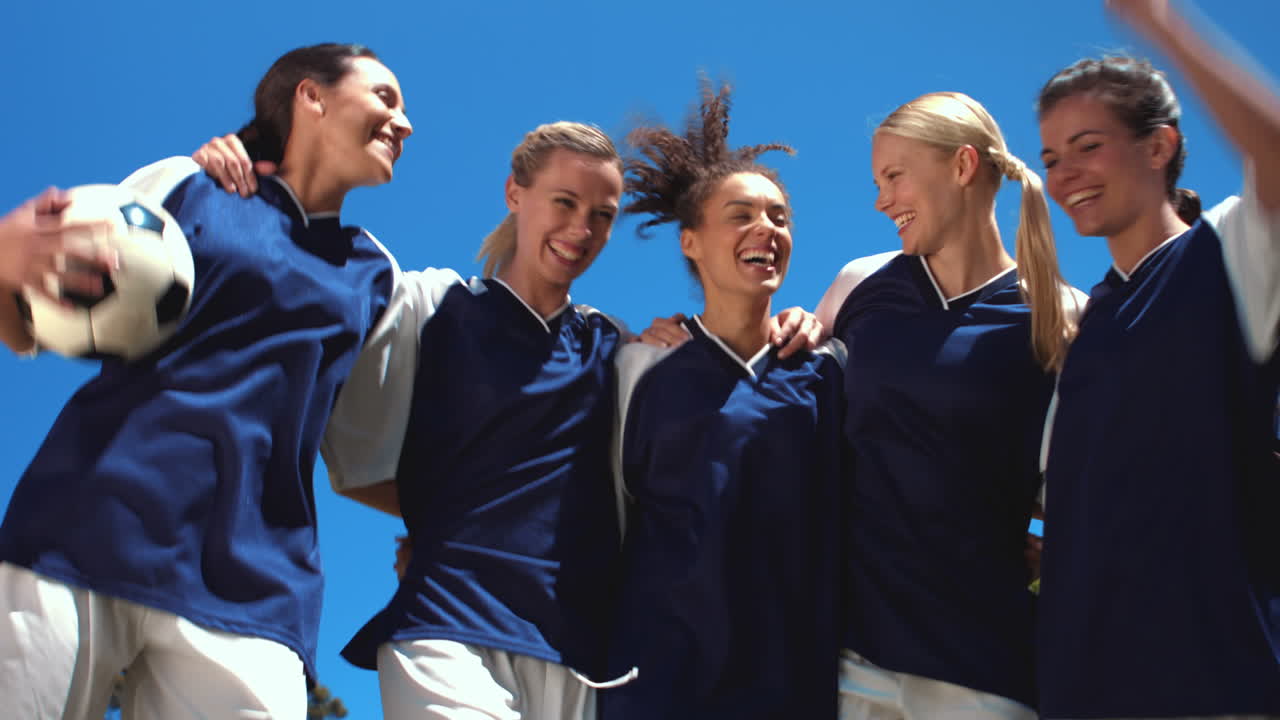 높은 품질의 형식으로 예쁜 축구 선수들이 카메라에 미소 짓고 있습니다.