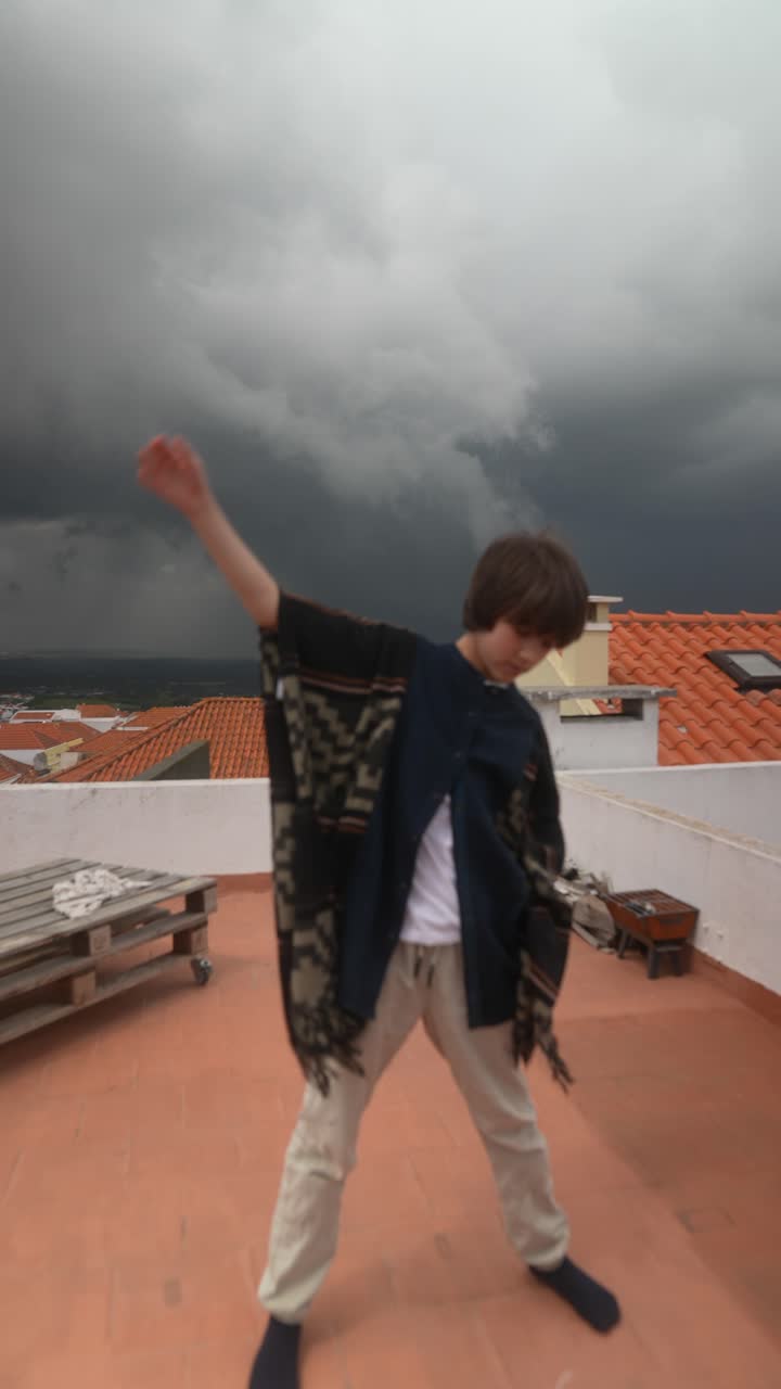 Bambino in posa su un tetto durante una tempesta