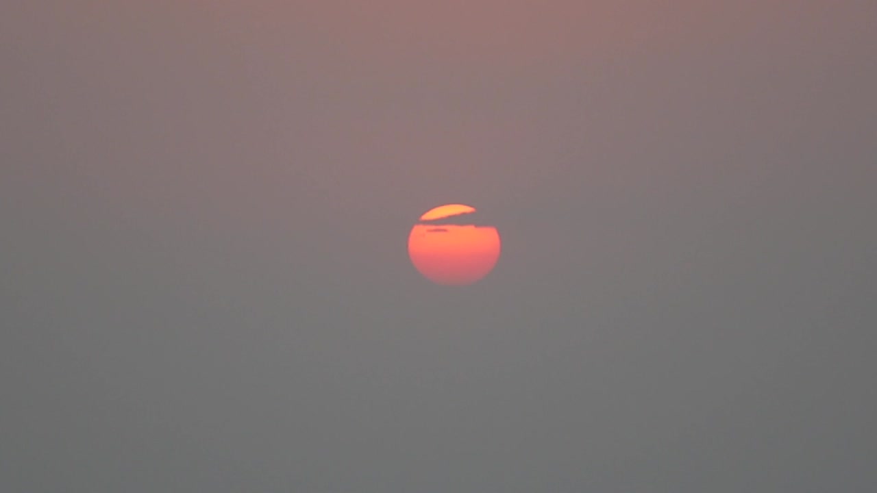 Sunset with a small cloud covering part of the sun. Mount Abu, Rajasthan, India.