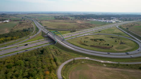 Toma-Panorámica-Aérea-De-La-Carretera-Y-El-Puente-Con-Muchos-Coches-Cerca-De-La-Ciudad-De-Gdansk,-Polonia