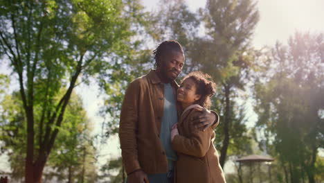 portrait loving father hugging smiling daughter looking each other green park.