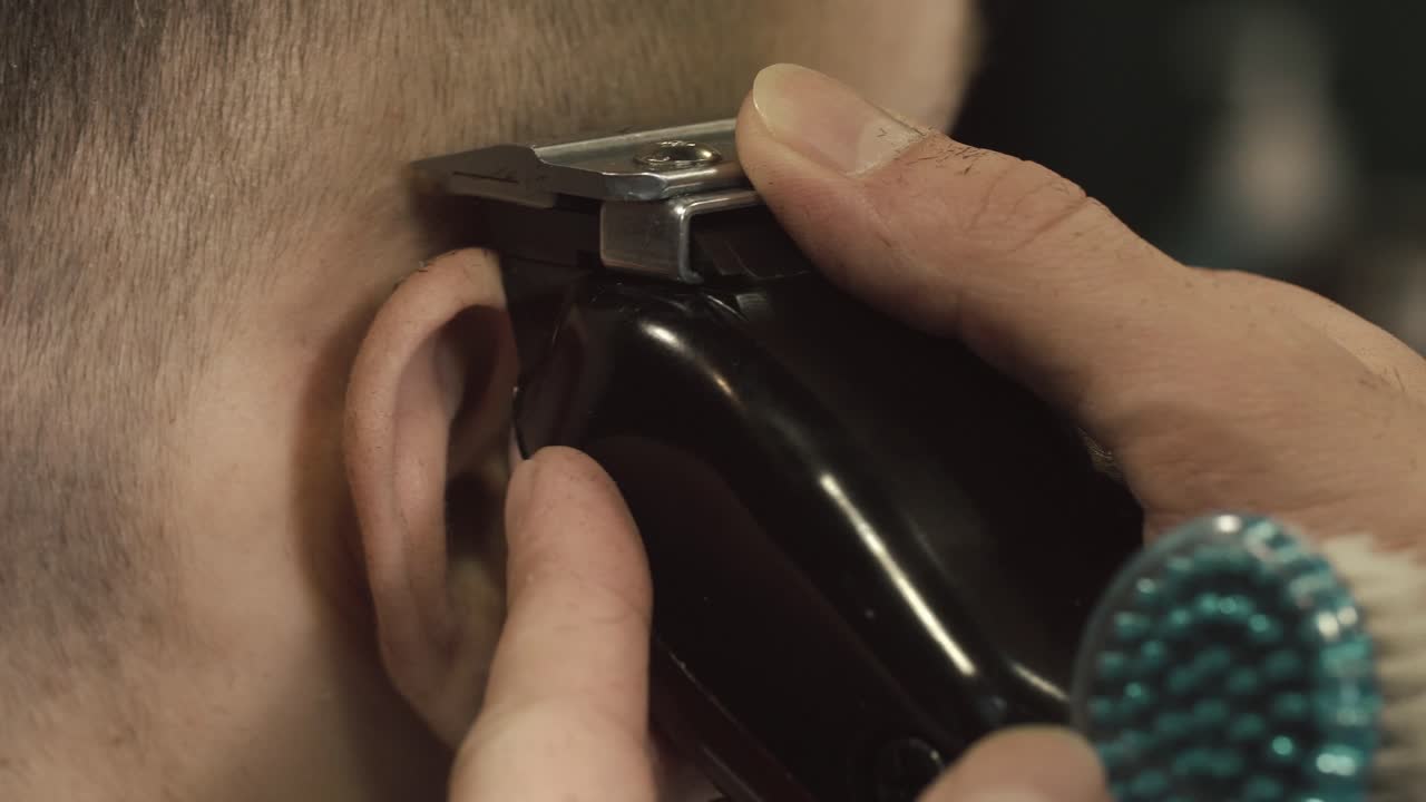 Close-up of a person receiving a haircut with electric clippers