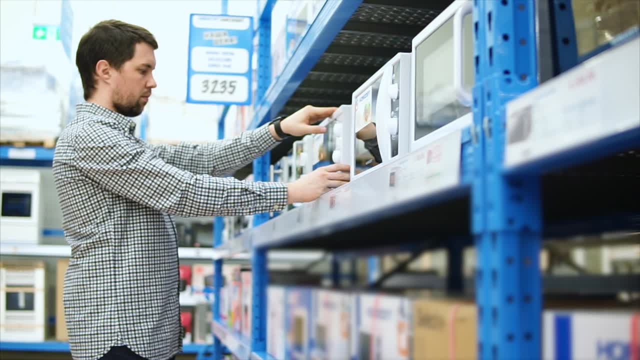 hombre comprando microondas en una tienda minorista