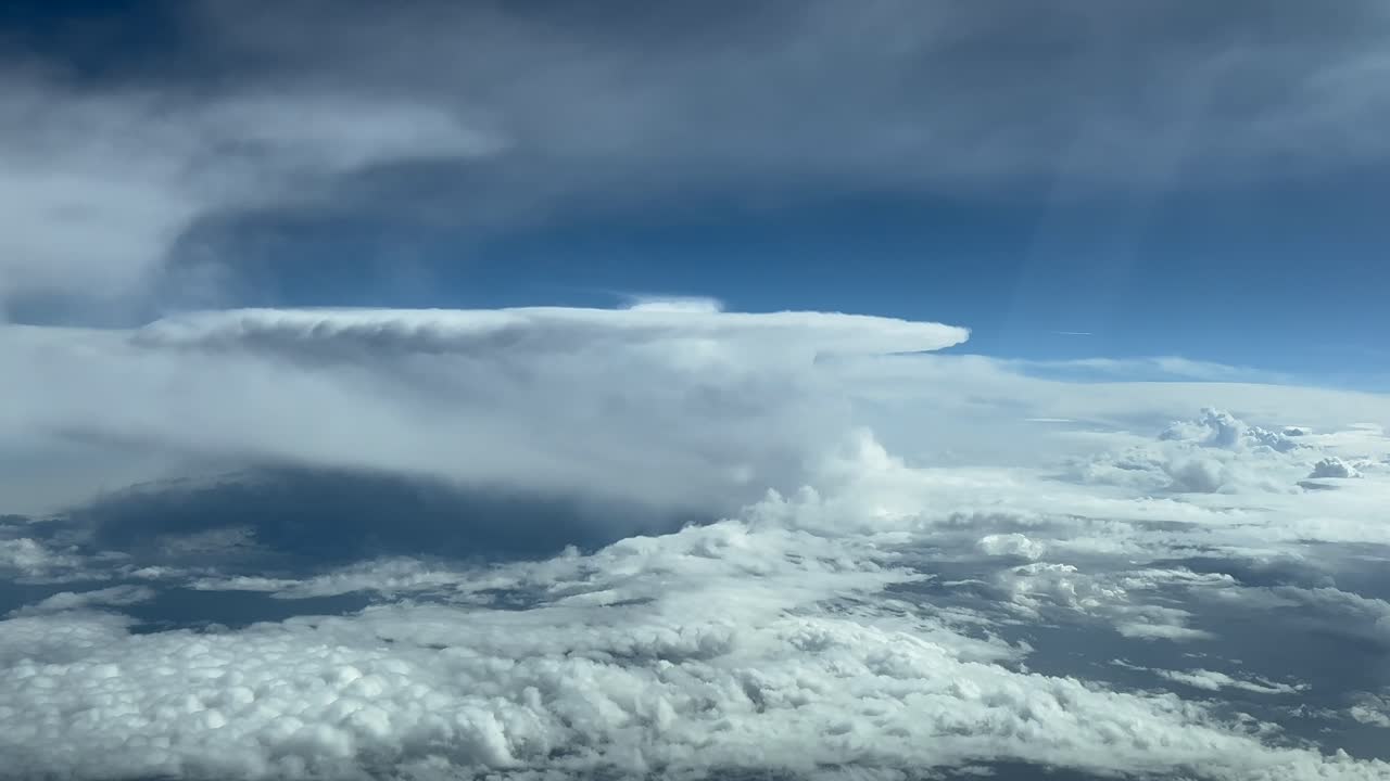 Immersive pilot POV FPV from the cockpit of a jet flying at cruise level through a stormy sky with a huge cumulonimbus storm cloud ahead. Unique pilot’s perspective of the sky ahead. 4K 60FPS