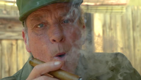 Slow-motion-footage-of-a-senior-male-puffing-a-cigar,-close-up