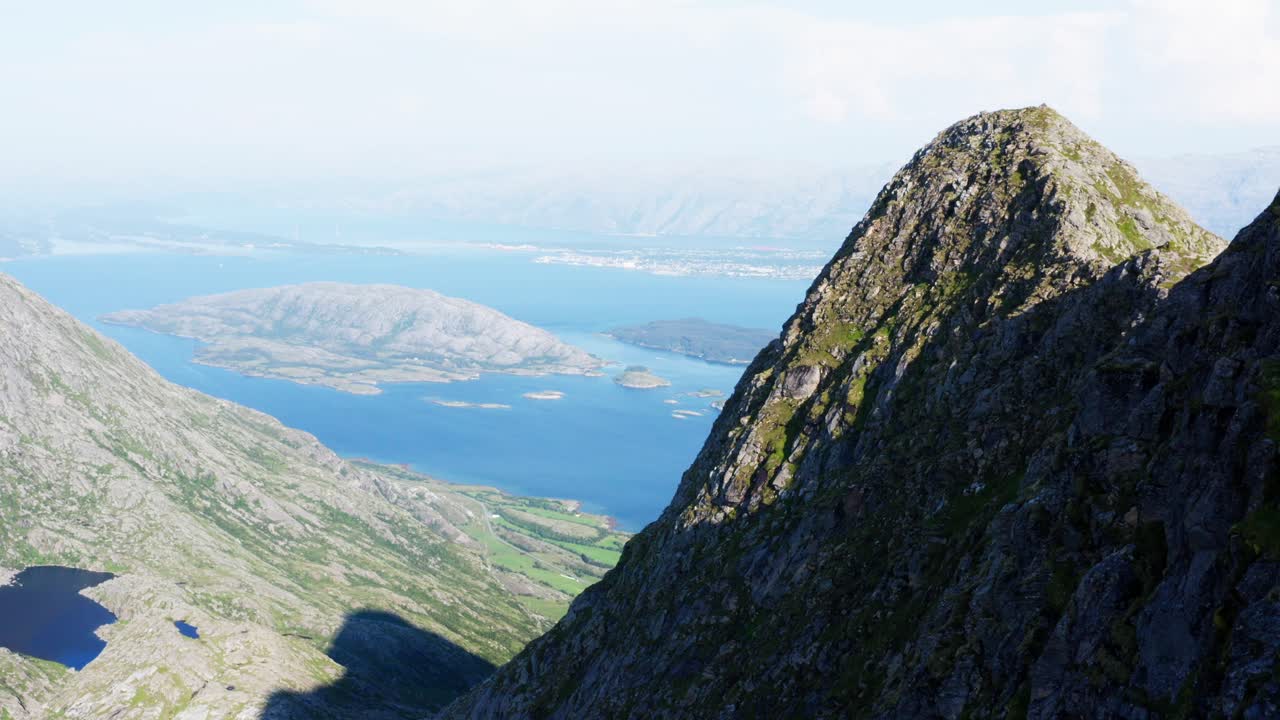 Nærbilde av den ulendte fjelltoppen Dønnamannen på øya Dønna på Helgeland med oversikt over Skorpa i Troms, Norge