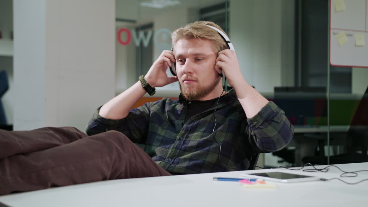 un joven usando una tableta y escuchando música