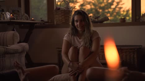 young female latin meditating sitting on a pillow in casual indoor spiritual class with big green window with vegetation in a wooden home in slow motion and 60fps
