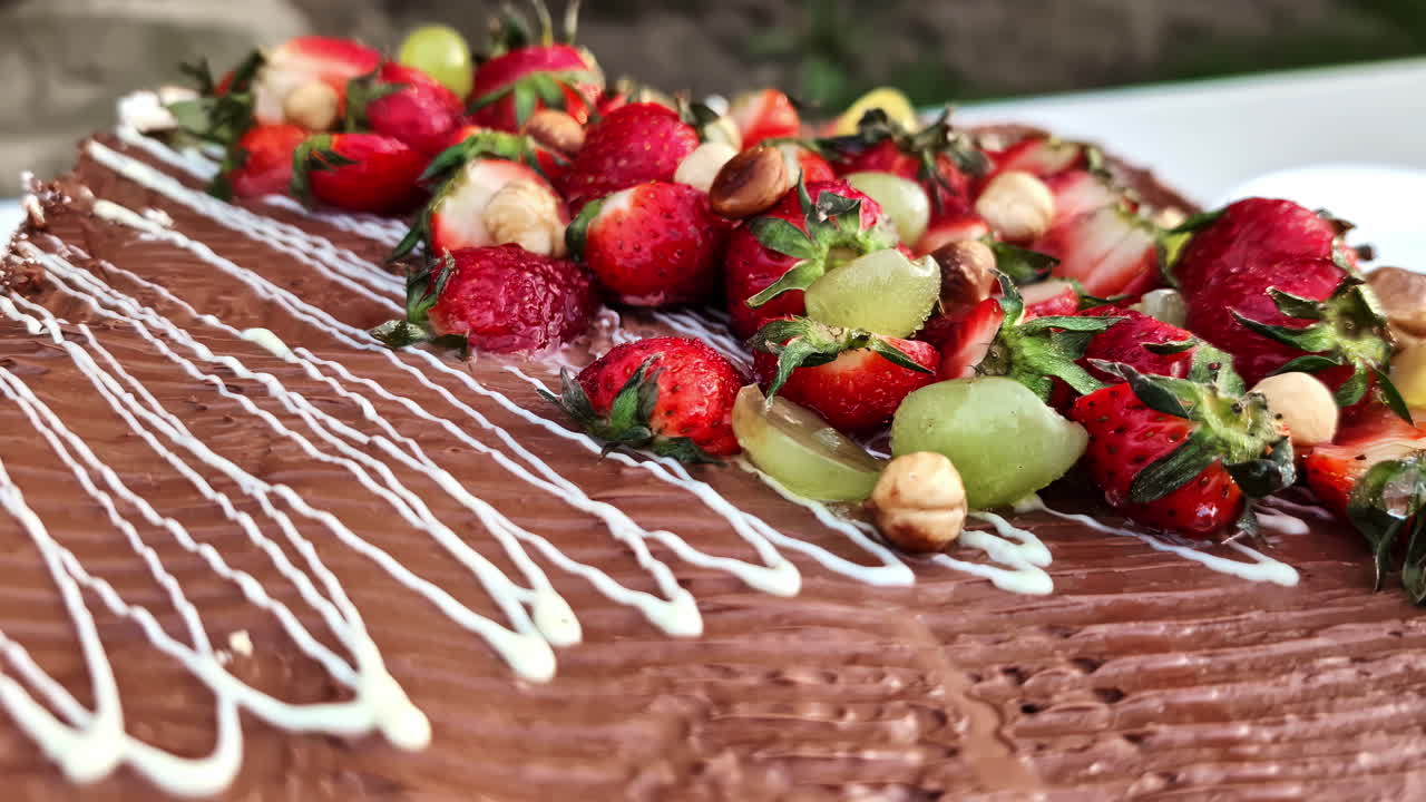 Chocolate cake glaze topping with fresh strawberry hazelnut and grapes dessert