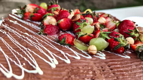 chocolate cake glaze topping with fresh strawberry hazelnut and grapes dessert