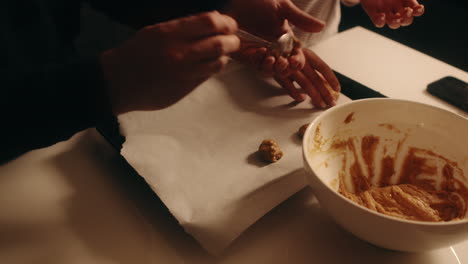 Friends-scoop-dough-from-mixing-bowl-rolling-into-balls-and-placing-on-baking-sheet