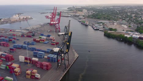 overhead scenic view of puerto de haina small port with colorful stacked cargo shipping containers and large cranes, dominican republic, above aerial