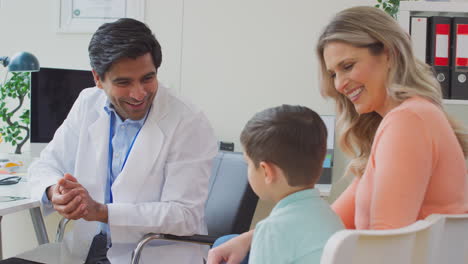 un médico sonriente o un médico de cabecera blanca se reúnen madre e hijo para una cita en la oficina