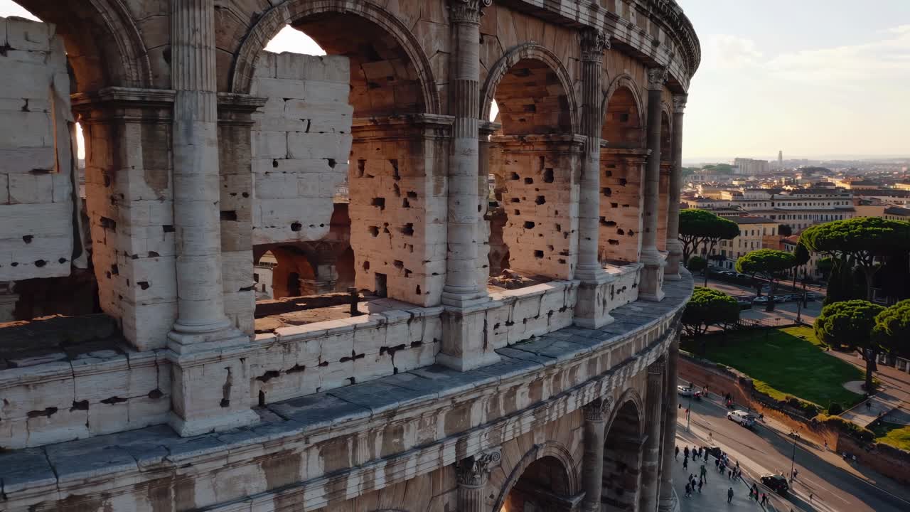 Aerial video of the Colosseum at sunset, showcasing its ancient architecture and the surrounding
