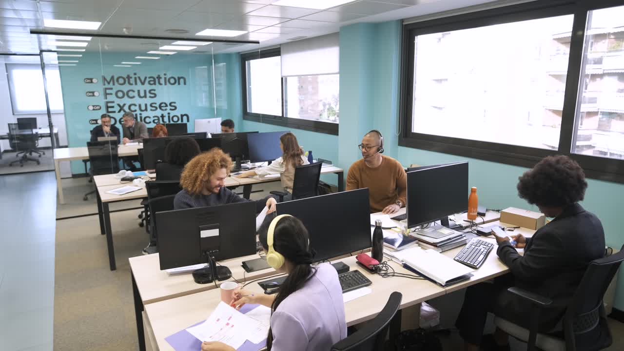 Diverse colleagues sitting at workplaces in office