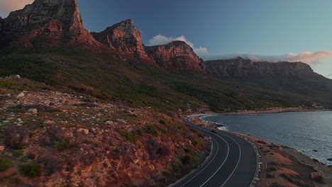 Vista-Del-Atardecer-De-Los-12-Apóstoles-Y-El-Parque-Nacional-Table-Mountain-A-Través-De-Victoria-Road-En-Ciudad-Del-Cabo,-Sudáfrica