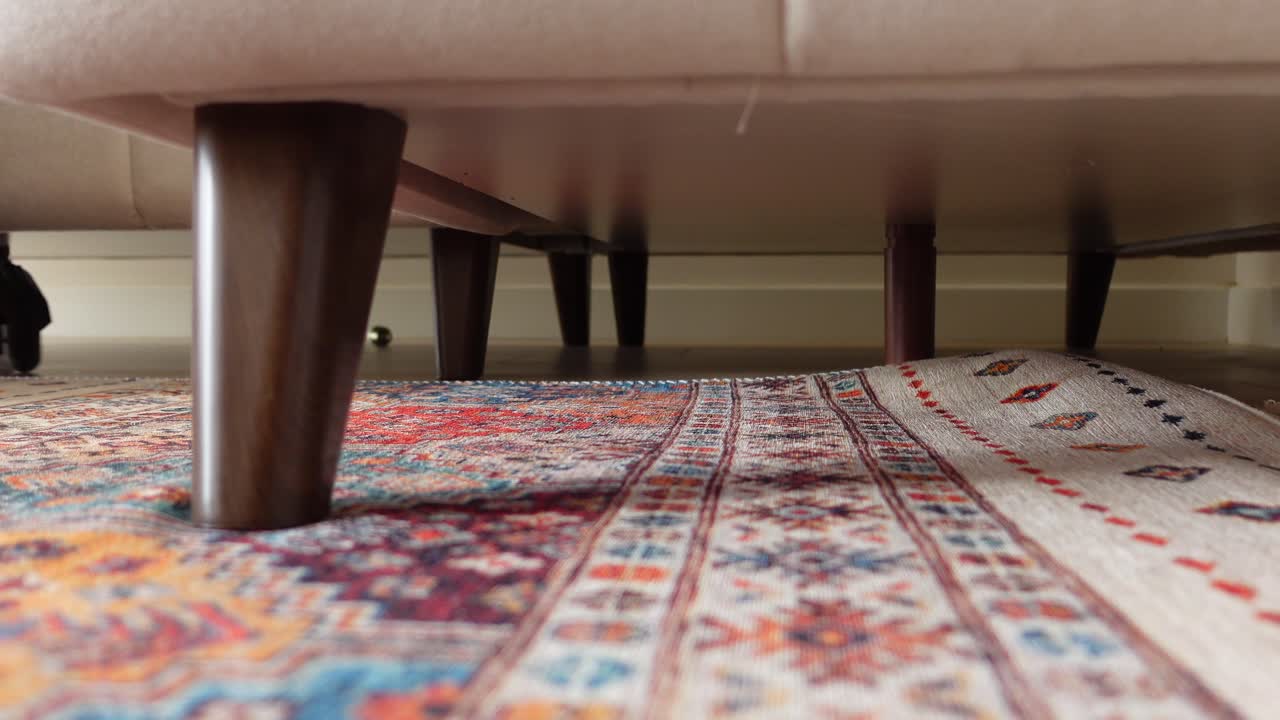 A Person Cleaning Under A Couch