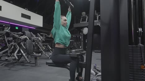 woman doing lat pulldowns at the gym