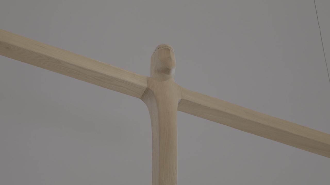 Carved wooden cross hangs in the sanctuary of a church, close up