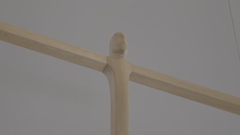 carved wooden cross hangs in the sanctuary of a church, close up