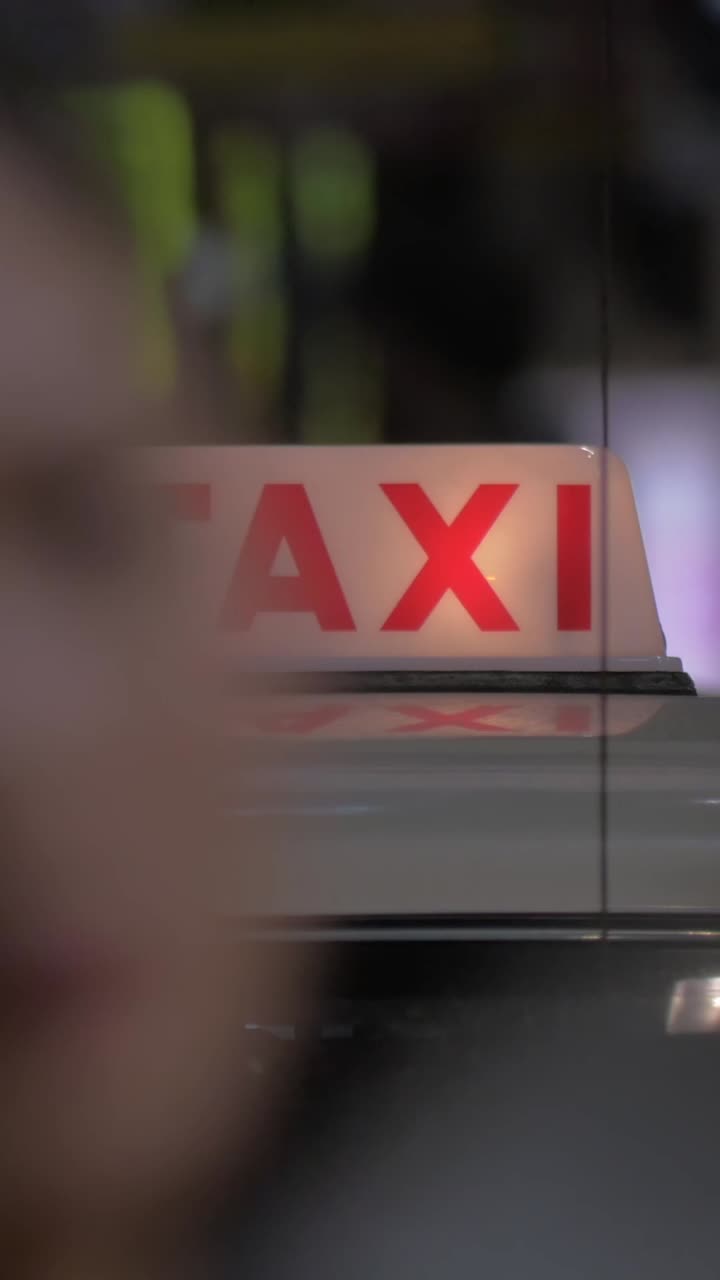 Insegna luminosa di taxi su un'auto in una città di notte