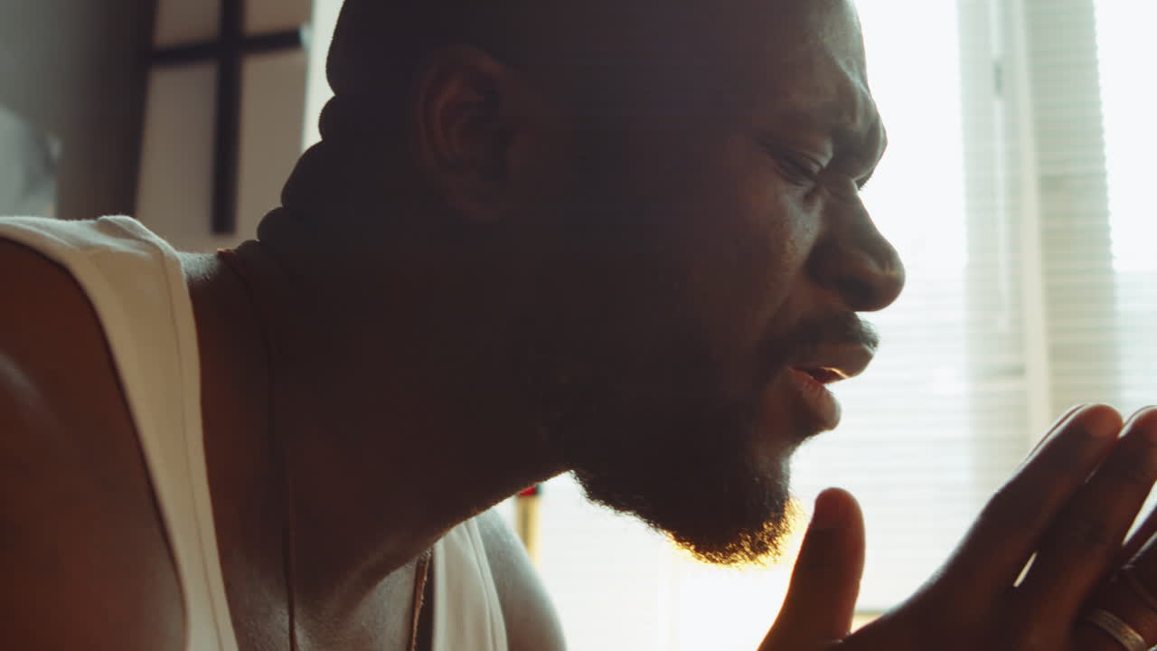 hombre negro diciendo una oración en casa