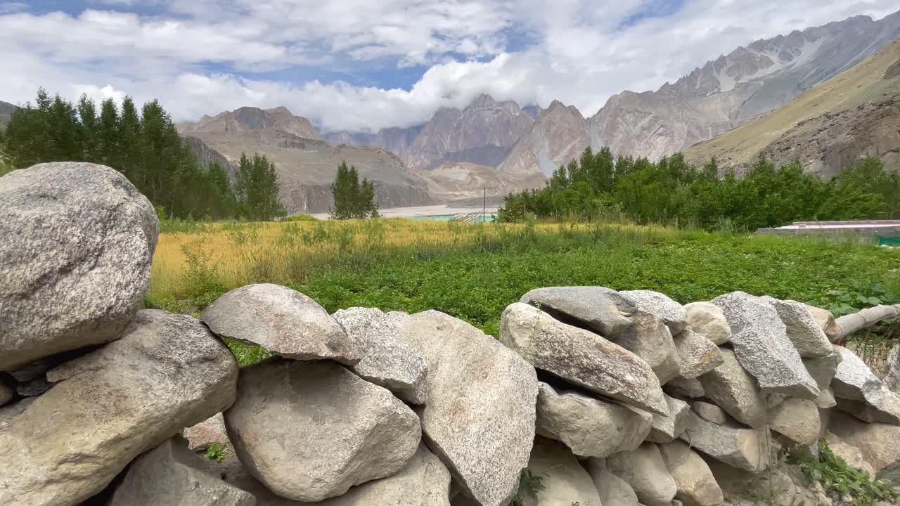 Capturing the breathtaking aerial view of skardu valley, showcasing lush green fields, dense forests, and majestic mountains under a partly cloudy sky, offering a serene and picturesque landscape