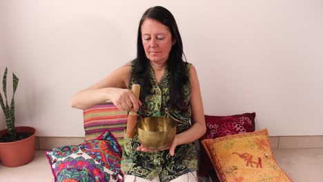 mujer de mediana edad con cuenco tibetano de bronce