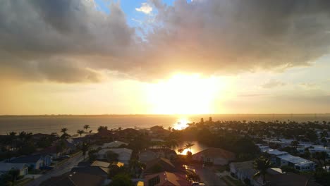 a beautiful 4k drone shot of houses in florida at sunset time with a slight tropical rain going through