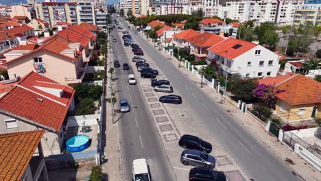 Drohnenaufnahme,-Die-Sich-Nach-Unten-Neigt-Und-Parallel-über-Etwas-Verkehr-Auf-Einer-Zweispurigen-Avenida-Fliegt