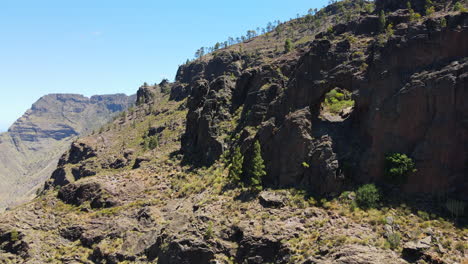 Tamadaba-natural-park,-Tirma:-aerial-view-traveling-out-to-rock-formations-with-a-hole