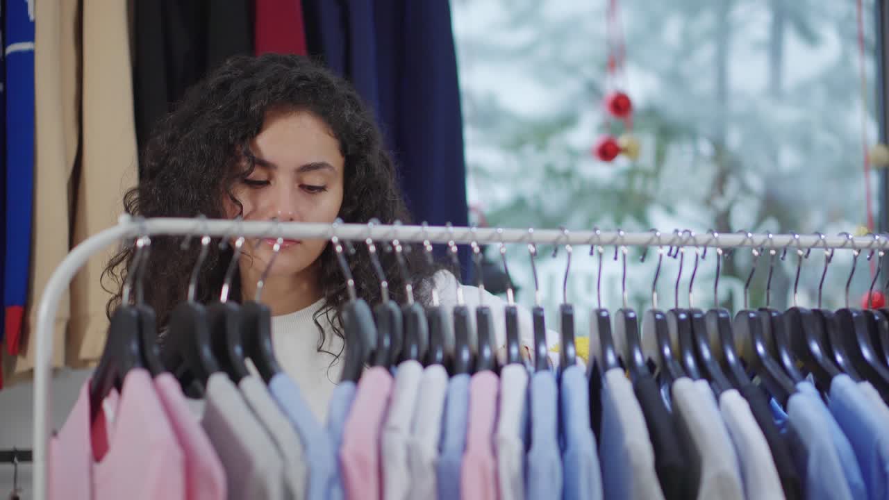mujer comprando camisetas en una tienda de ropa