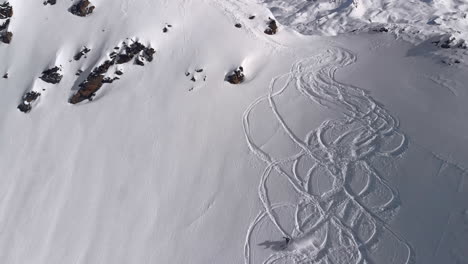 Aerial-French-Apls----Skifahrer,-Der-Den-Abhang-Der-Französischen-Alpen-Hinunterfährt-Und-Am-Ende-Abfällt