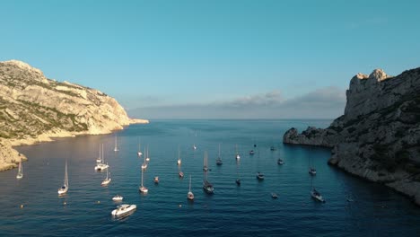 aerial revealing shot of sailboats anchored in the nice bay during summer