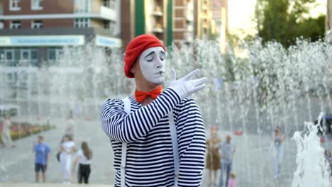 funny mime conducting and has fun at the fountain background