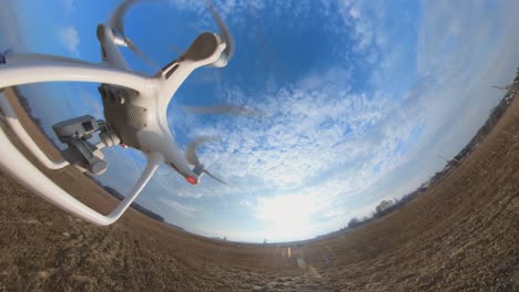 Close-up-Side-View-of-Dji-Phantom-4-Quadcopter-Drone-Flying-Over-Fields