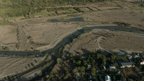 Aerial-View-Of-The-Aragvi-River-By-The-Village-And-Vast-Landscape-In-Georgia---ascending-drone-shot